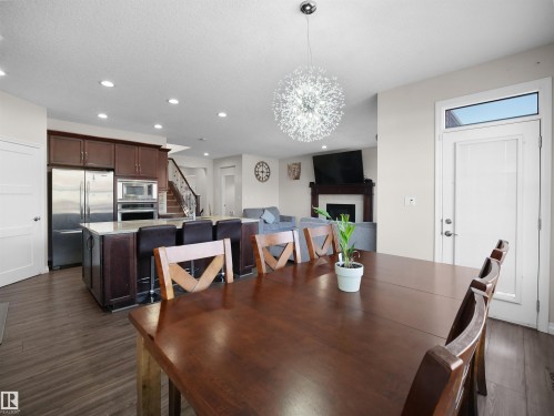 This open-concept living space features dark wood flooring, recessed lighting, and a modern light fixture - 4405 Crabapple Landing Landing, Edmonton, AB - Indoor Photo Showing Dining Room