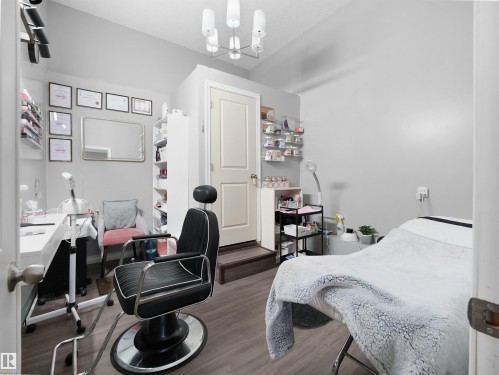 This versatile room features light grey walls and durable wood-look flooring, providing a clean and adaptable space - 4405 Crabapple Landing Landing, Edmonton, AB - Indoor Photo Showing Bedroom