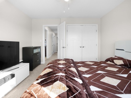 This room features light-colored walls and carpeted flooring, with a ceiling fan - 4405 Crabapple Landing Landing, Edmonton, AB - Indoor Photo Showing Bedroom