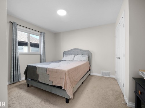 The room features light-colored walls, carpeted flooring, and a window with curtains - 4405 Crabapple Landing Landing, Edmonton, AB - Indoor Photo Showing Bedroom