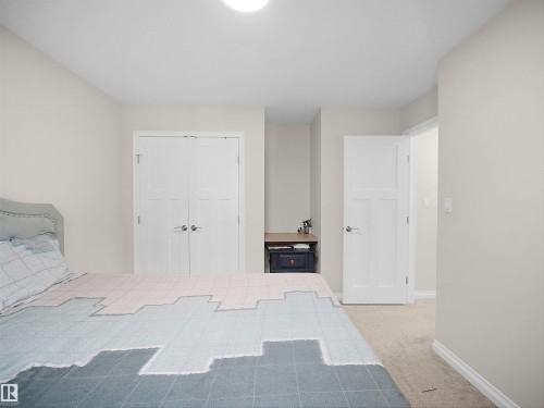 This room features light-colored walls and carpeting, a ceiling light fixture, and white doors with silver-toned hardware - 4405 Crabapple Landing Landing, Edmonton, AB - Indoor Photo Showing Bedroom