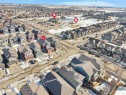 Aerial view of the neighborhood showcasing residential properties with diverse architectural styles and rooflines, including solar panels on some homes - 4405 Crabapple Landing Landing, Edmonton, AB  - Outdoor With View 