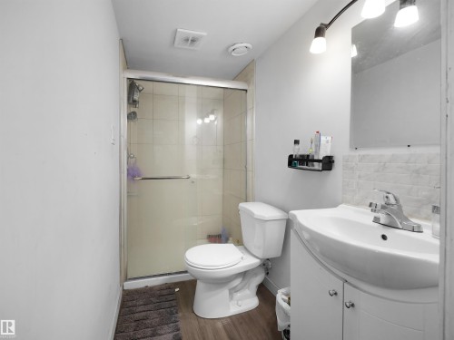 Bathroom featuring a glass-enclosed shower, a vanity with an integrated sink, and wood-look flooring - 4405 Crabapple Landing Landing, Edmonton, AB - Indoor Photo Showing Bathroom