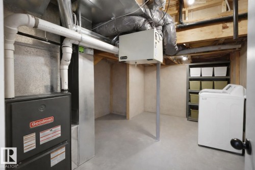 The property features a utility area with a Goodman furnace, exposed ceiling beams, and a washer - 4405 Crabapple Landing Landing, Edmonton, AB - Indoor