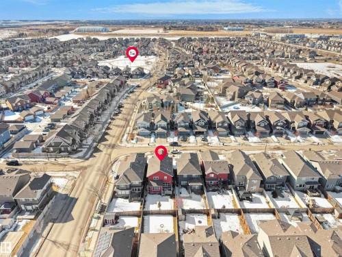 Aerial view of the neighborhood showcasing numerous residential properties with varying roof styles and colors, and streets with visible vehicle parking - 4405 Crabapple Landing Landing, Edmonton, AB - Outdoor With View