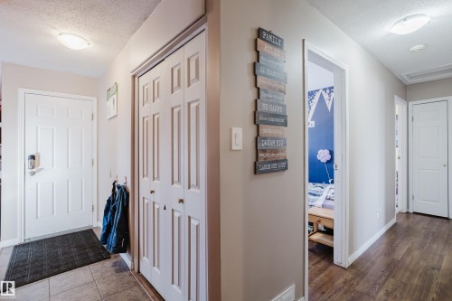 The entryway features tile flooring, a white paneled door, and a closet with bifold doors - 8707 151 Avenue, Edmonton, AB - Indoor Photo Showing Other Room