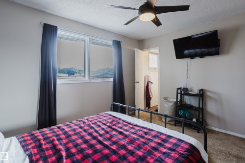 This room features light-colored walls, carpeting, and a ceiling fan with integrated lighting - 8707 151 Avenue, Edmonton, AB - Indoor Photo Showing Bedroom