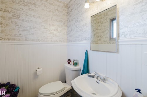 Bathroom featuring wainscoting and brick-patterned wallpaper - 8707 151 Avenue, Edmonton, AB - Indoor Photo Showing Bathroom