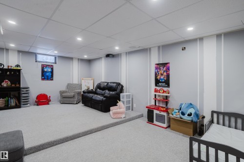 The property features a spacious room with light gray carpeting, recessed lighting, and a drop ceiling - 8707 151 Avenue, Edmonton, AB - Indoor Photo Showing Basement