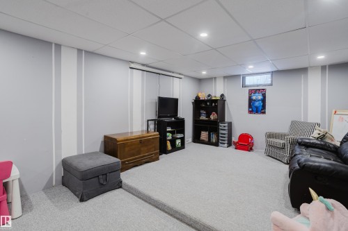 This spacious room features light grey carpeting, recessed lighting, and a drop ceiling - 8707 151 Avenue, Edmonton, AB - Indoor Photo Showing Basement
