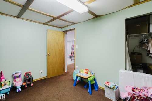 This room features light green walls and brown carpeting - 8707 151 Avenue, Edmonton, AB - Indoor
