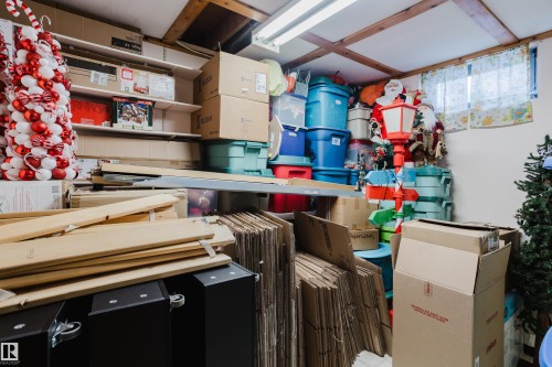 The property features a utility room with exposed wooden ceiling beams and a window with a curtain - 8707 151 Avenue, Edmonton, AB - Indoor