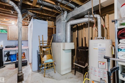 The utility area features exposed ceiling joists, a water heater, and visible ductwork - 8707 151 Avenue, Edmonton, AB - Indoor Photo Showing Basement