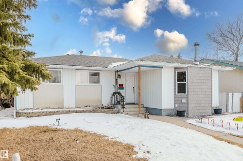 The property features a white exterior with grey shingle siding accents and a contrasting blue trim under the eaves - 8707 151 Avenue, Edmonton, AB - Outdoor