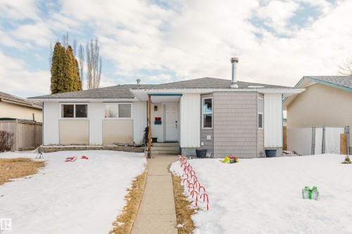 The property features a ranch-style exterior with a white facade and gray shingle siding accents - 8707 151 Avenue, Edmonton, AB - Outdoor With Facade