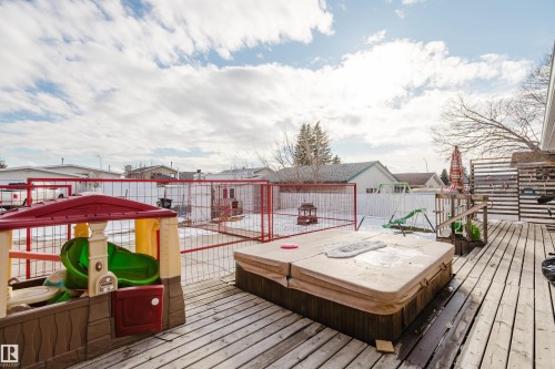 The property features an outdoor deck with a hot tub, providing an inviting space for relaxation - 8707 151 Avenue, Edmonton, AB - Outdoor With Deck Patio Veranda