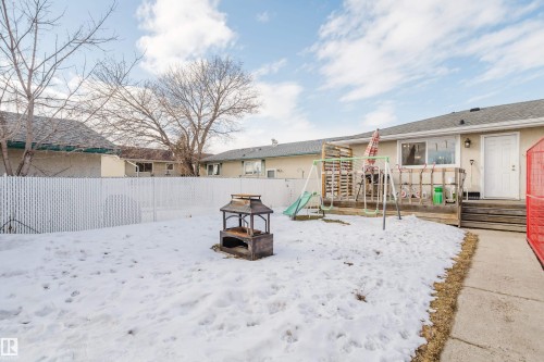 The property features a fenced backyard with a patio area and a separate concrete walkway - 8707 151 Avenue, Edmonton, AB - Outdoor