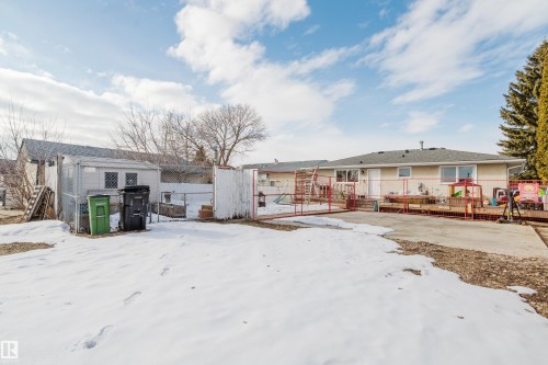 The property features a spacious backyard with a paved patio, an expansive deck, and a shed - 8707 151 Avenue, Edmonton, AB - Outdoor