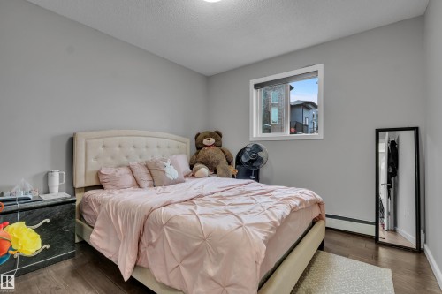 Well-lit room featuring hardwood flooring and a window providing natural light - 320 392 Silver Berry Road, Edmonton, AB - Indoor Photo Showing Bedroom