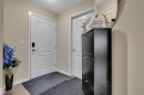 Entryway featuring a white door with a modern handle and a wall-mounted light switch - 320 392 Silver Berry Road, Edmonton, AB  - Indoor Photo Showing Other Room 