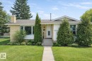 The property features a well-maintained front yard with a lush lawn, mature trees, and established landscaping - 11415 32 Avenue, Edmonton, AB  - Outdoor 