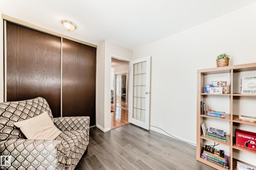 This versatile room features durable flooring, a closet with sliding doors, and a doorway with a glass-paned door - 11415 32 Avenue, Edmonton, AB - Indoor Photo Showing Other Room