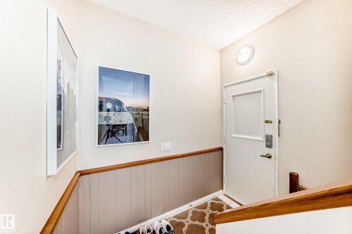 Entryway featuring wainscoting with a wooden top rail and a white door with a window panel - 11415 32 Avenue, Edmonton, AB - Indoor Photo Showing Other Room
