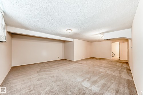 This spacious room features neutral-toned carpet, recessed lighting, and ample wall space - 11415 32 Avenue, Edmonton, AB - Indoor Photo Showing Other Room