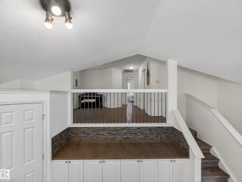 The property features an open loft area with a vaulted ceiling and track lighting - 1665 Tompkins Place, Edmonton, AB - Indoor Photo Showing Other Room