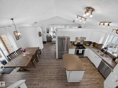 This property features a kitchen with white cabinetry, stainless steel appliances, and a central island - 1665 Tompkins Place, Edmonton, AB - Indoor