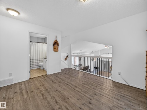 This area features hardwood-style flooring and a clean white wall finish - 1665 Tompkins Place, Edmonton, AB - Indoor Photo Showing Other Room