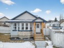 The property features light blue siding, a welcoming front entrance with wooden steps and a white door, and a bay window with a stone foundation - 1665 Tompkins Place, Edmonton, AB  - Outdoor 