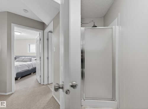 The property features a shower with a frosted glass door and a chrome shower head - 1665 Tompkins Place, Edmonton, AB - Indoor