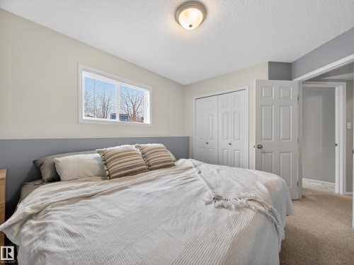 Bedroom with carpeted flooring, a window providing natural light, and bi-fold closet doors - 1665 Tompkins Place, Edmonton, AB - Indoor Photo Showing Bedroom
