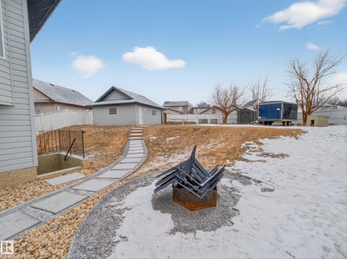 This property features a spacious yard with a paved walkway leading to a detached garage - 1665 Tompkins Place, Edmonton, AB - Outdoor