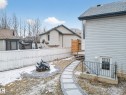 The property features an exterior with light-colored siding, a dark roof, and a wooden deck with stairs - 1665 Tompkins Place, Edmonton, AB  - Outdoor With Exterior 