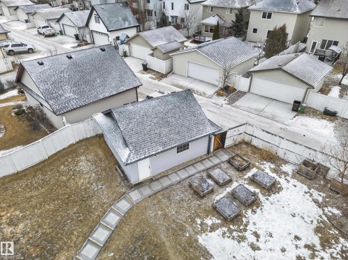 This property features a detached garage with a shingled roof and a white overhead door - 1665 Tompkins Place, Edmonton, AB - Outdoor