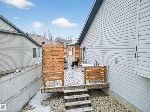 The property features an outdoor deck with wooden privacy screens and steps leading down to a gravel area - 1665 Tompkins Place, Edmonton, AB - Outdoor With Exterior