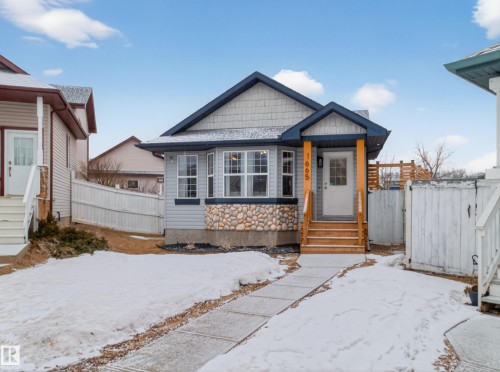 The property features a light blue exterior with shingle and horizontal siding, accented by stone detailing - 1665 Tompkins Place, Edmonton, AB - Outdoor