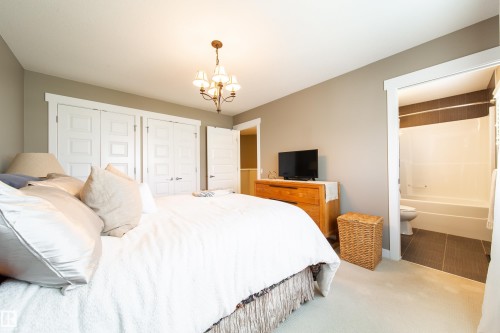 The property features a bedroom with neutral-toned walls, light-colored carpeting, and white bi-fold closet doors - 3451 Cutler Crescent, Edmonton, AB - Indoor Photo Showing Bedroom
