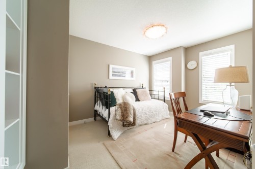 This room features carpeted flooring, two windows with blinds, and a built-in white shelving unit - 3451 Cutler Crescent, Edmonton, AB - Indoor