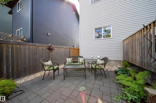 The property features a paved patio area, bordered by a wooden fence and decorative gravel - 3451 Cutler Crescent, Edmonton, AB - Outdoor With Deck Patio Veranda With Exterior