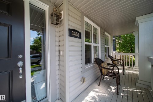 Welcoming front porch featuring a dark entry door, decorative outdoor lighting, and ample space for seating - 3451 Cutler Crescent, Edmonton, AB - Outdoor With Deck Patio Veranda With Exterior