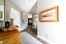 The property features hardwood flooring throughout the hallway, a white staircase with handrails, and neutral-toned walls - 3451 Cutler Crescent, Edmonton, AB  - Indoor 