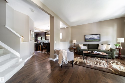 The main living area features hardwood floors, light-colored walls, and a staircase with white risers and carpeting - 3451 Cutler Crescent, Edmonton, AB - Indoor Photo Showing Living Room