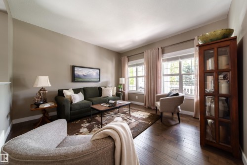 The living room features hardwood flooring, two large windows providing natural light, and neutral-toned walls - 3451 Cutler Crescent, Edmonton, AB - Indoor Photo Showing Living Room