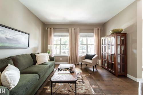 This living area features rich hardwood flooring and neutral-toned walls - 3451 Cutler Crescent, Edmonton, AB - Indoor Photo Showing Living Room