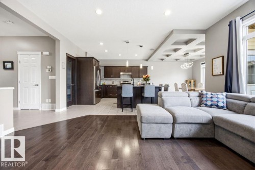 This property features rich hardwood flooring that spans the main living areas, complemented by tiled flooring in the kitchen - 13024 206 Street, Edmonton, AB - Indoor Photo Showing Living Room