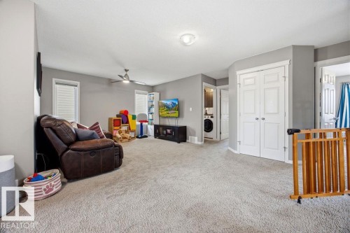 Spacious room featuring light gray walls, carpet flooring, a ceiling fan, and white doors - 13024 206 Street, Edmonton, AB - Indoor