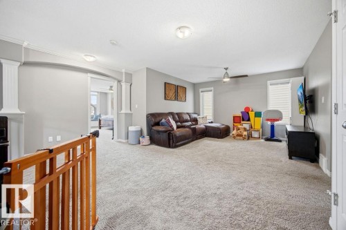 Spacious living area featuring light gray walls, plush gray carpeting, and a ceiling fan - 13024 206 Street, Edmonton, AB - Indoor